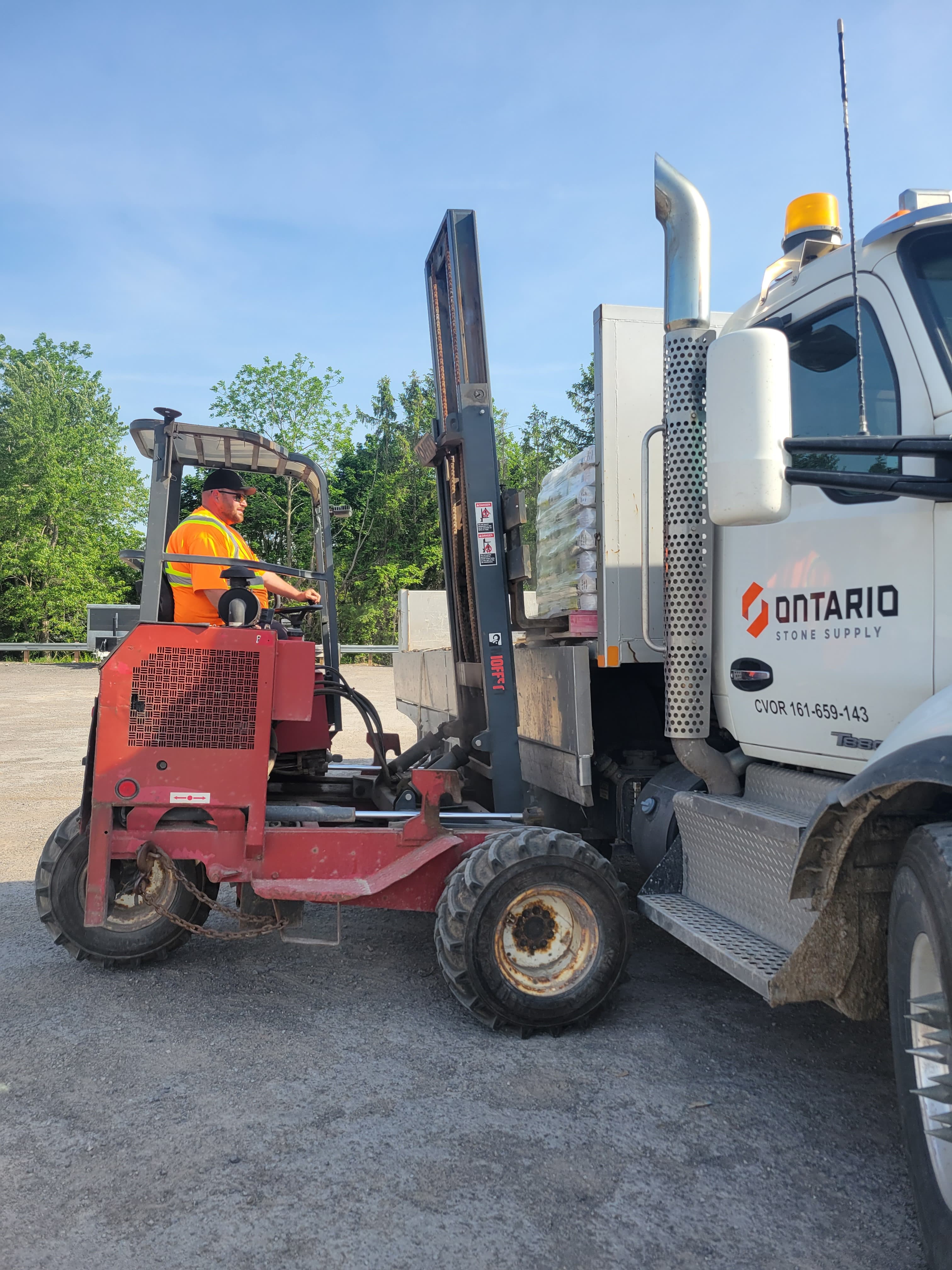 Forklift loading truck with bricks